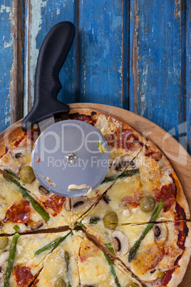 Delicious pizza served on pizza tray with cutter