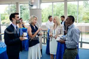 Business executives interacting with each other while having coffee