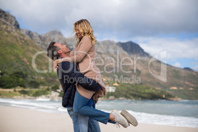 Mature man holding mature woman on beach