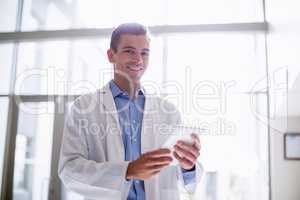 Portrait of doctor using digital tablet in hospital corridor
