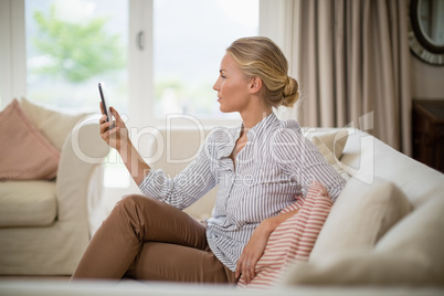 Woman using mobile phone in living room