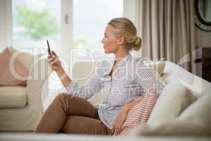 Woman using mobile phone in living room