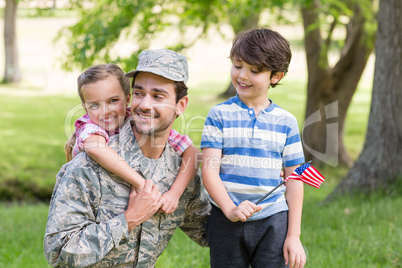 Happy soldier reunited with his son and daughter in park