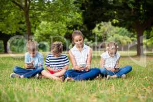 Kids using mobile phone in park