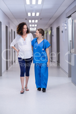 Doctor interacting with pregnant woman in corridor