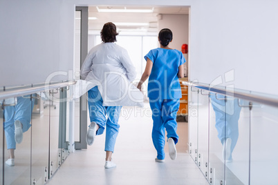 Nurse and doctor running in hospital corridor