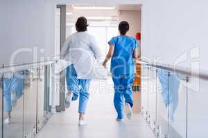 Nurse and doctor running in hospital corridor