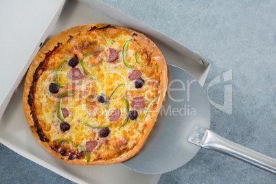 Pizza being placed in a box