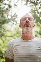Man meditating against bright sunlight