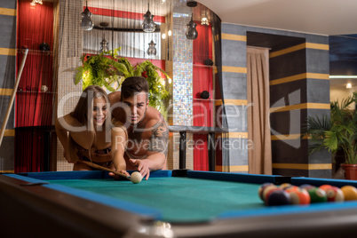 Young sexy pair playing billiards in sauna
