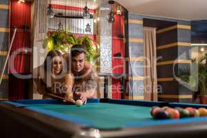 Young sexy pair playing billiards in sauna