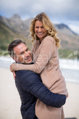 Mature man holding mature woman on beach