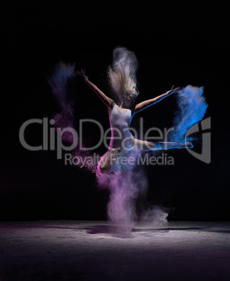 Dancer jumping in cloud of powder, in motion