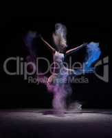 Dancer jumping in cloud of powder, in motion