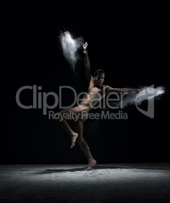 Naked dancer in motion in cloud of powder