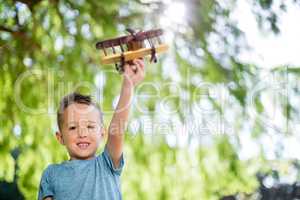 Portrait of boy playing with a toy aeroplane in park