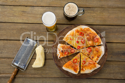 Italian pizza served on a pizza tray with a beer mug and glass