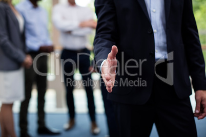 Mid section of business executives shaking hands