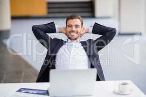 Happy businessman relaxing at desk