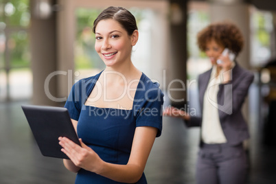 Confident and beautiful business executive holding digital tablet