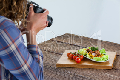 Photographer clicking a picture of food using digital camera