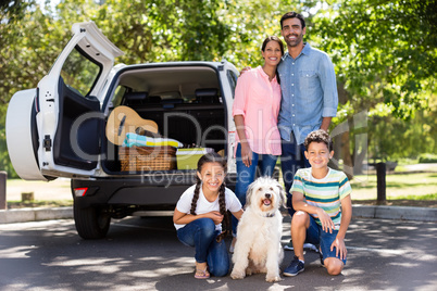 Portrait of happy family next to their car having fun