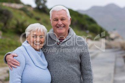 Happy senior couple standing together on the beach