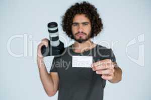 Male photographer showing visiting card in studio