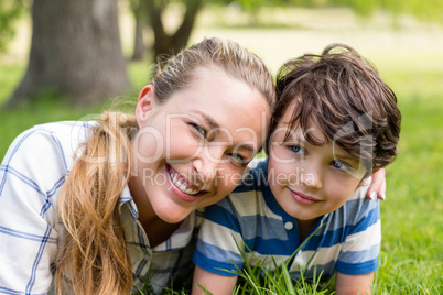 Happy mother and son lying in park