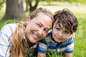 Happy mother and son lying in park