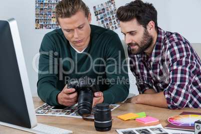 Photographers reviewing captured photos in digital camera
