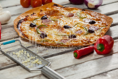 Italian pizza on wooden plank with vegetables and spices