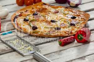 Italian pizza on wooden plank with vegetables and spices