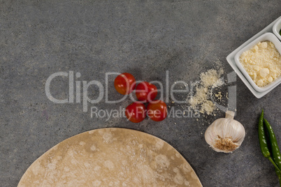 Pizza dough and ingredient on grey background