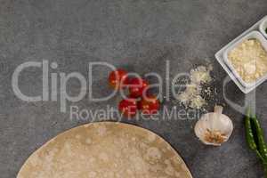 Pizza dough and ingredient on grey background