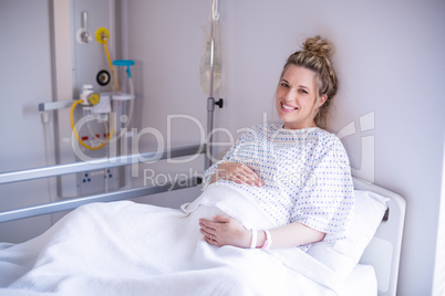 Portrait of pregnant woman relaxing on hospital bed