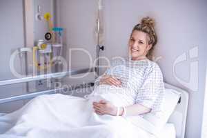 Portrait of pregnant woman relaxing on hospital bed
