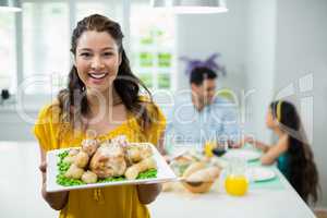 Portrait of happy woman standing with meal in tray