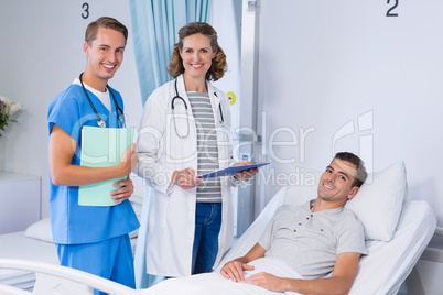Portrait of doctors and patient in hospital bed