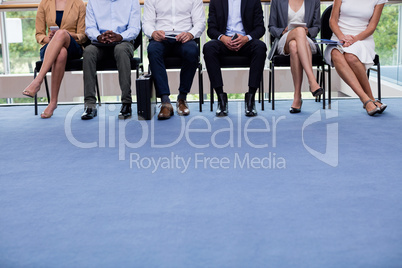 Business executives sitting on chair at conference center lobby