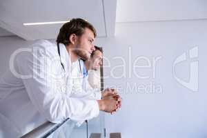 Doctors leaning on railing in corridor