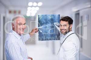 Portrait of doctor and patient holding x-ray in corridor
