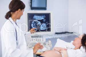 Doctor doing ultrasound for pregnant woman