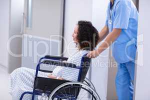 Doctor pushing a pregnant woman on wheelchair