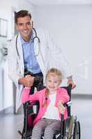 Portrait of doctor pushing girl in wheelchair