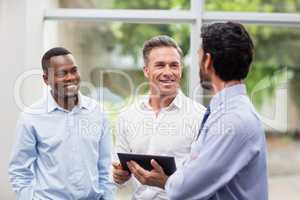 Business executives discussing over digital tablet