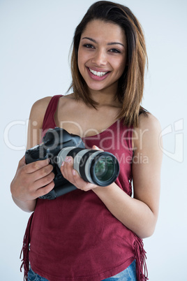 Happy female photographer standing in studio