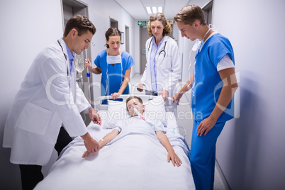 Doctors pushing emergency stretcher bed in corridor