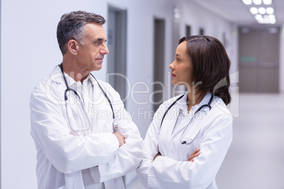 Doctors standing with arms crossed in corridor