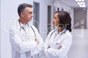 Doctors standing with arms crossed in corridor